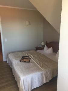 a hotel room with a bed with a book on it at Strandhotel Deichgraf Graal-Müritz in Graal-Müritz