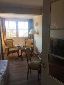 ein Hotelzimmer mit einem Bett, einem Tisch und Stühlen in der Unterkunft Strandhotel Deichgraf Graal-Müritz in Graal-Müritz