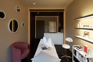 a room with a bed and a chair and a kitchen at first mountain Hotel Montafon in Gaschurn