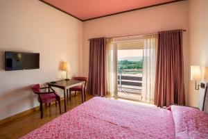 a bedroom with a bed and a desk and a window at Dera Masuda Luxury Resort in Pushkar