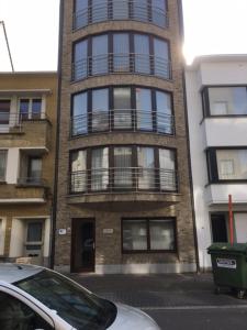 a tall building with a car parked in front of it at Duinenwachter in Knokke-Heist
