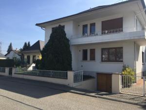 une maison blanche avec une clôture devant elle dans l'établissement Appartement Orana, à Oberhausbergen