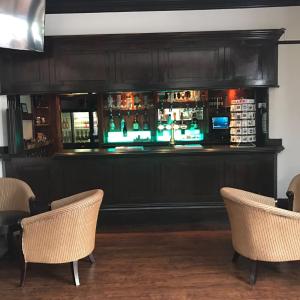 a bar with a television on the wall at Harefield Manor Hotel in Romford