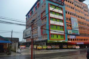 a tall building with colorful windows on a city street at Puncak Budget Hotel in Pangkalpinang