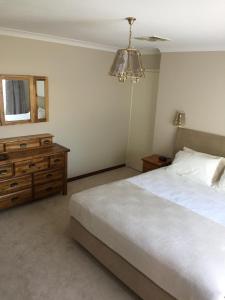 a bedroom with a bed and a dresser and a mirror at Murdoch Station in Perth