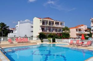 a large swimming pool with chairs and a building at Limenaria Beach in Limenaria