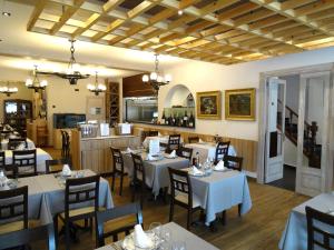 un restaurante con mesas y sillas blancas y una cocina en Hotel Victoria, en Tossa de Mar