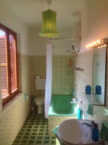 a bathroom with a green tub and a sink at Casa "Le tre Muse" in Deruta