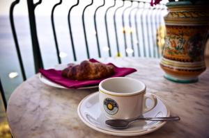 een kop koffie en een bord eten op een tafel bij Bay Palace Mazzarò in Taormina