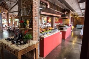 a restaurant with a counter with food on it at Hotel Fazenda Santa Monica in Louveira
