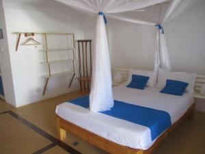 1 dormitorio con 1 cama con dosel en Le Jardin de L'isle en Ifaty