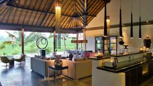 a lobby of a resort with couches and a bar at Rouge - Private Villa Condense in Ubud