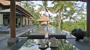 a resort with a swimming pool and a villa at Rouge - Private Villa Condense in Ubud