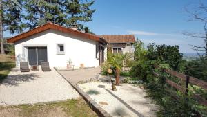 ein kleines weißes Haus mit einem Zaun davor in der Unterkunft La Villa du Chatelard in Ambierle
