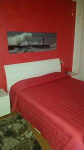 a red bedroom with a bed with a red bedspread at Savonaamare in Savona