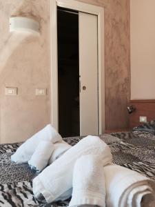 a pile of towels on a bed in front of a mirror at Hotel Villa Flora in Bogliasco