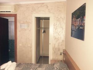a bedroom with a bed and a refrigerator in it at Hotel Villa Flora in Bogliasco