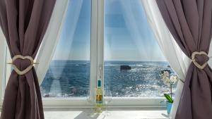 a window with a view of the ocean at MarLove Siracusa - Stunning Views & Private Sea Access in Syracuse