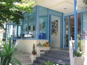 un bâtiment avec du verre bleu et des escaliers en façade dans l'établissement Hotel Festival, à Rimini