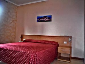 a bedroom with a bed with a red comforter at Hotel Villa Flora in Bogliasco
