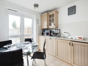 a kitchen with a table with chairs and a window at My-Places Abbotsfield Court Townhouse 4 in Manchester