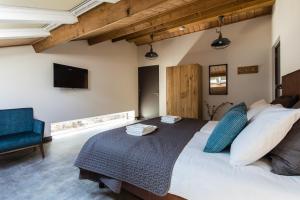 Mariahout因德黑住宿加早餐旅馆的一间卧室，有一张大床和一把蓝色椅子