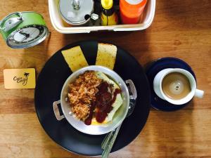 a bowl of breakfast food on a plate with a cup of coffee at Coco Coozy in Kanchanaburi City