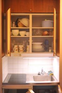 a kitchen cabinet with a sink and dishes in it at Studio Les Menuires Brelin in Les Menuires