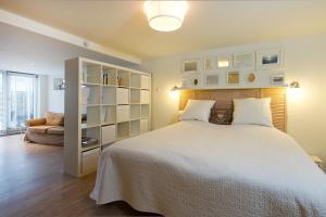 ein Schlafzimmer mit einem großen weißen Bett und einem Sofa in der Unterkunft Studio Sautille in Zandvoort