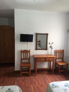 a room with two chairs and a table and a mirror at Hostal Pancorbo in Pancorbo