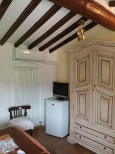 a bedroom with a tv and a white cabinet at Le Travi in Sarzana