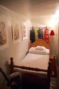 カルカソンヌにあるLa Gaffeのベッドルーム1室(ベッド1台付)、ランプ、壁の絵画が備わります。