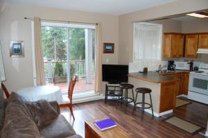 uma cozinha e sala de estar com um sofá e uma mesa em Belle Neige Suites: Whistler em Whistler
