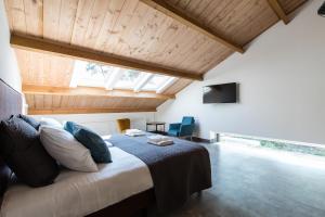 een slaapkamer met een groot bed in een kamer met houten plafonds bij In de Hei in Mariahout