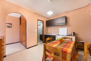 a kitchen and a dining room with a table with a bowl of fruit at Symi Sunshine Apartment in Symi