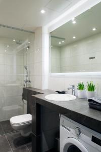 Un baño con lavabo, inodoro y espejo. en Vana-Posti Apartment, en Tallin 5 fotos más