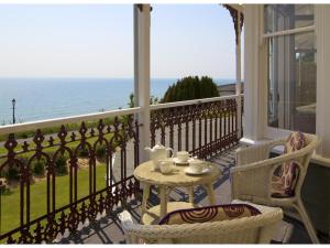 a dining room table with a balcony overlooking the ocean at The Clifton in Shanklin