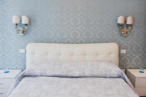 een slaapkamer met een wit bed met 2 verlichting aan de muur bij Arte&Musica in Verona +16 foto's