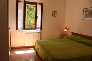 a bedroom with a green bed and a window at Appartamenti Anna in Rio Marina