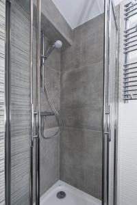La salle de bains est pourvue d'une douche avec une porte en verre. dans l'établissement At home in lyon, à Lyon