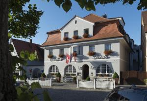 een wit gebouw met een rood dak bij Hotel Gasthof Zum Storch in Schlüsselfeld
