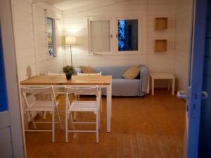 uma sala de estar com uma mesa e cadeiras e um sofá em Camping Azahar em Benicàssim