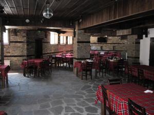 a dining room with red tables and chairs and brick walls at Hotel Deyanira in Gorno Dryanovo
