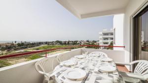 a dining room with a table and chairs on a balcony at Apartamentos Vista Mar in Armação de Pêra