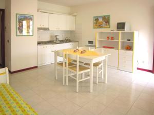 a kitchen with a table and chairs in a room at Appartamenti Alaska in Bibione +9 photos