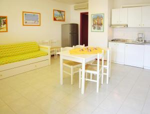 a kitchen and dining room with a table and a couch at Appartamenti Alaska in Bibione