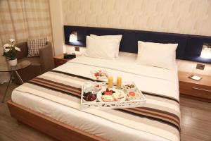 Una habitación de hotel con una cama con una bandeja de comida encima. en Urban Central Suites - Beirut, en Beirut 82 fotos más