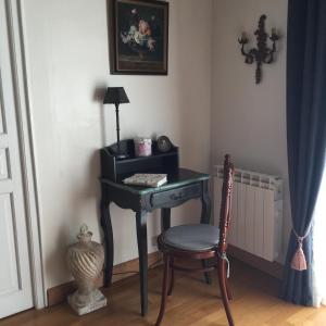 un bureau noir avec une chaise et une lampe dans l'établissement B&B les Agapanthes, à Gasny