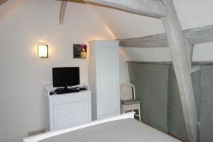 a room with a tv on a dresser with a television at Boudin Cottage Honfleur in Honfleur