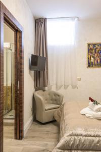 ein Schlafzimmer mit einem Bett, einem Stuhl und einem Fenster in der Unterkunft Rifugio degli Artisti Top B&B in Rom